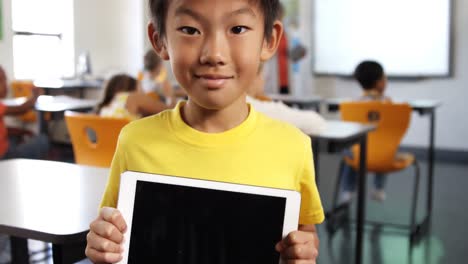 Porträt-Eines-Jungen,-Der-Im-Klassenzimmer-Ein-Digitales-Tablet-Hält