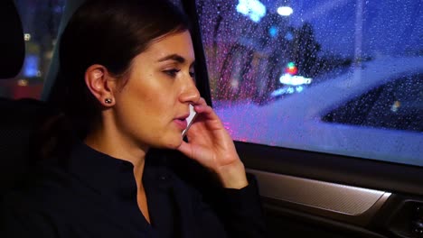 Businesswoman-talking-on-mobile-phone-while-travelling-in-car