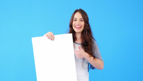 Beautiful-woman-holding-blank-placard-and-showing-thumbs-up
