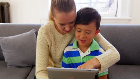 Mutter-Und-Sohn-Nutzen-Digitales-Tablet-Im-Wohnzimmer