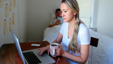 Mujer-Usando-Laptop-Mientras-El-Hombre-Usa-Tableta-Digital