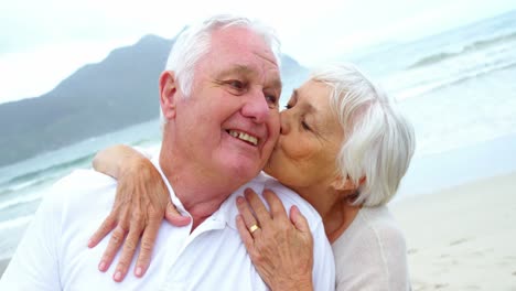 Senior-couple-embracing-each-other-on-the-beach