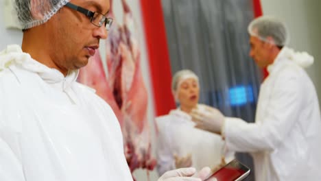 Female-butcher-using-digital-tablet
