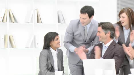 Panorama-of-business-team-applauding-a-colleague-in-office