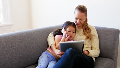 Mutter-Und-Tochter-Nutzen-Digitales-Tablet-Im-Wohnzimmer
