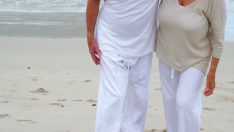Happy-senior-couple-walking-on-the-beach