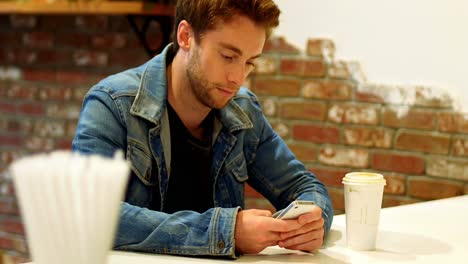 Man-using-mobile-phone-at-table