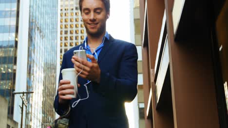 Businessman-listening-to-music-and-using-mobile-phone