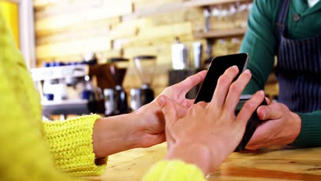 Frau-Bezahlt-Rechnung-Per-Smartphone-Mit-NFC-Technologie