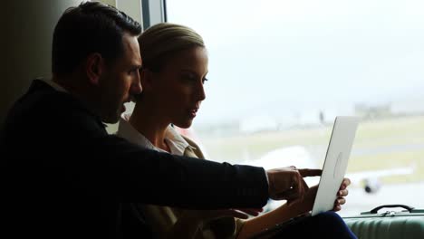 Businessman-and-woman-discussing-on-laptop