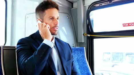 Businessman-talking-on-mobile-phone-while-travelling