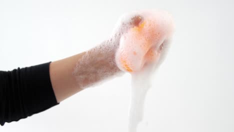 Close-up-of-hand-squeezing-cleaning-sponge