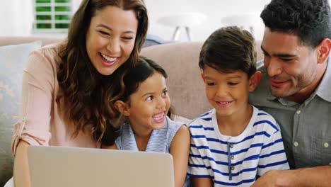 Happy-family-using-laptop-in-living-room