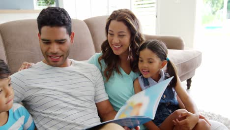 Happy-family-reading-book-in-living-room