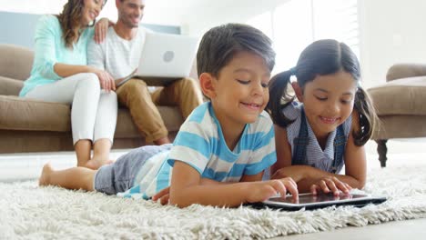 Familia-Feliz-Usando-Computadora-Portátil-Y-Tableta-Digital-En-La-Sala-De-Estar