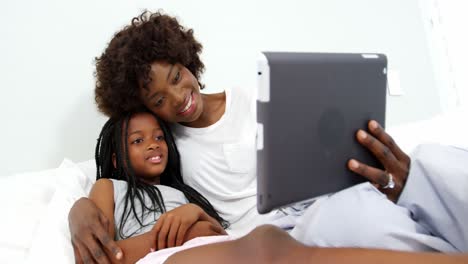 Madre-E-Hija-Usando-Tableta-Digital-En-El-Dormitorio