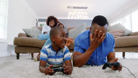 Father-and-son-playing-video-game-in-living-room-
