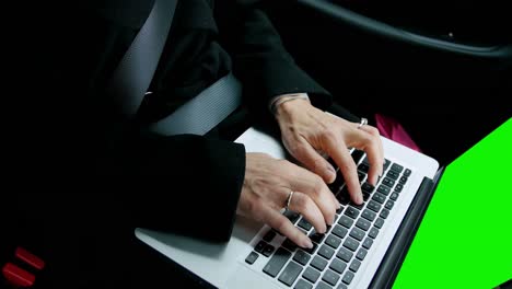 Businesswoman-sitting-in-car-and-using-laptop