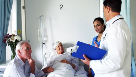 Doctor-discussing-report-with-senior-couple