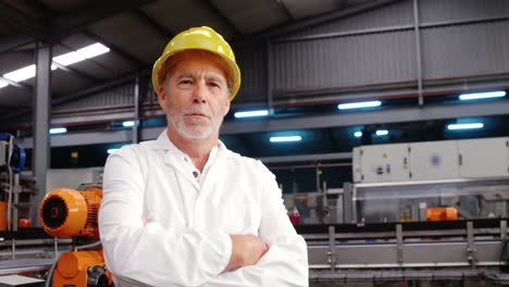 Worker-standing-with-arms-crossed-in-factory