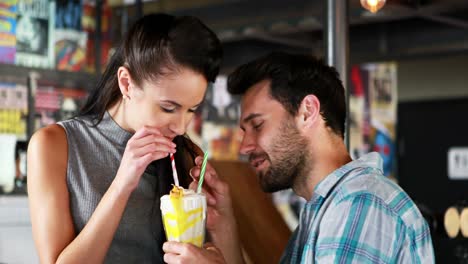 Happy-couple-interacting-while-having-milkshake