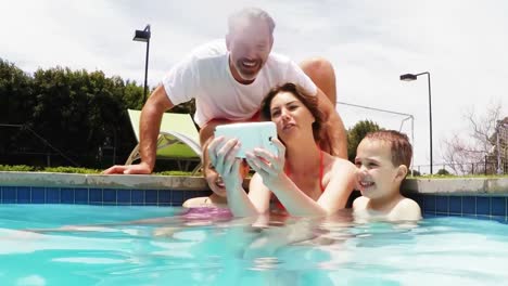 Family-talking-selfie-from-mobile-phone-at-pool-side