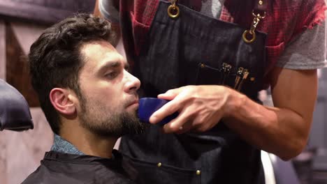 Man-getting-his-beard-trimmed-with-trimmer