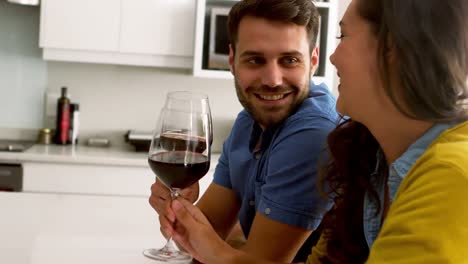 Couple-toasting-glasses-of-wine-in-kitchen