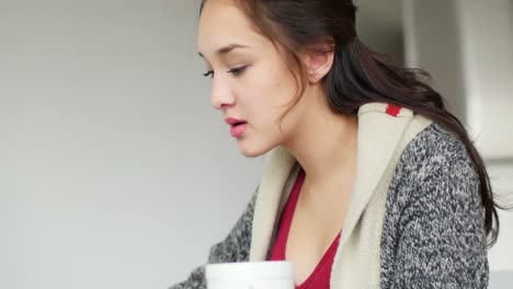 Woman-having-coffee-while-using-laptop