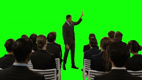 Businessman-using-futuristic-digital-screen-while-giving-presentation-to-colleagues