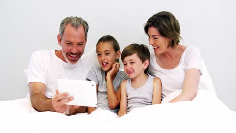 Familia-Usando-Tableta-Digital-En-El-Dormitorio