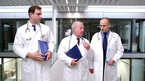 Doctors-interacting-with-each-other-while-walking-in-corridor