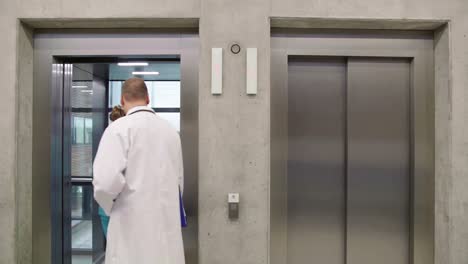 Doctor-and-nurse-interacting-with-each-other-and-entering-in-lift