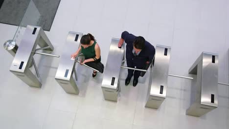 Businesspeople-scanning-their-cards-at-turnstile-gate