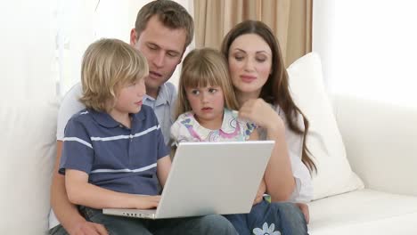 Familia-Usando-Una-Computadora-Portátil-En-La-Sala-De-Estar