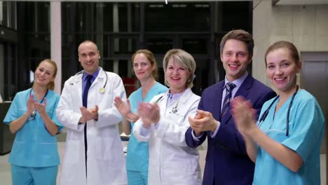 Team-of-doctors-and-businessman-applauding-during-meeting