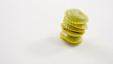 Stack-of-several-green-homemade-ravioli-pasta-on-white-background