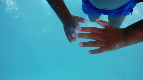 Niño-Nadando-Bajo-El-Agua-En-La-Piscina