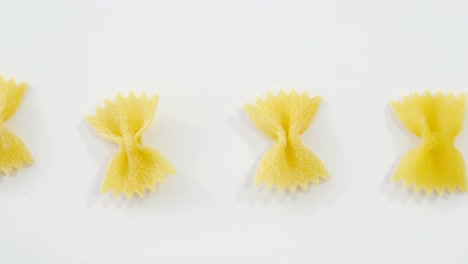 Row-of-bow-tie-pasta-on-white-background