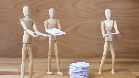 Business-wooden-figurine-standing-and-holding-document