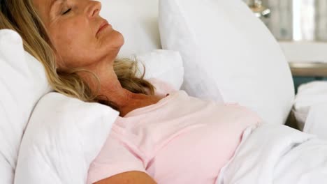 Senior-woman-sleeping-on-bed-in-bed-room