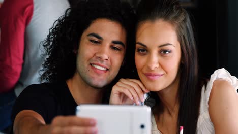 Couple-taking-selfie-on-mobile-phone-in-pub