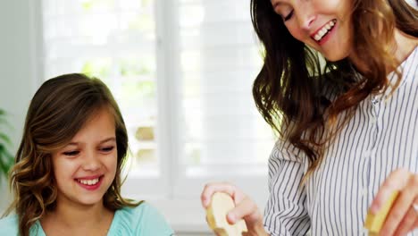 Mother-and-daughter-preparing-salad-together-in-kitchen