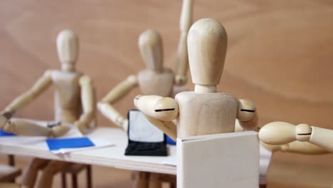 Wooden-figurines-having-meeting-in-conference-room