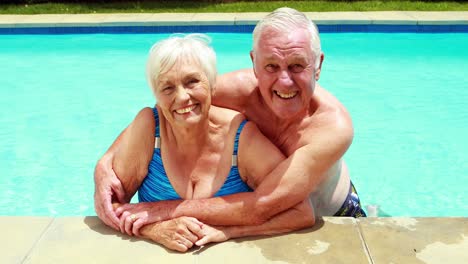 Portrait-of-senior-couple-embracing-each-other-in-pool