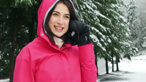 Smiling-woman-in-warm-clothing-talking-on-mobile-phone