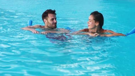 Smiling-couple-swimming-with-inflatable-tubes