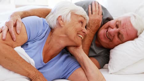 Happy-senior-couple-interacting-with-each-other-on-bed-
