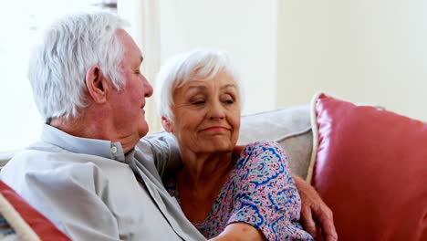 Senior-couple-talking-while-watching-television-in-living-room