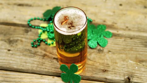 Pint-of-beer-with-shamrocks-decoration-on-wooden-table-for-st-patricks